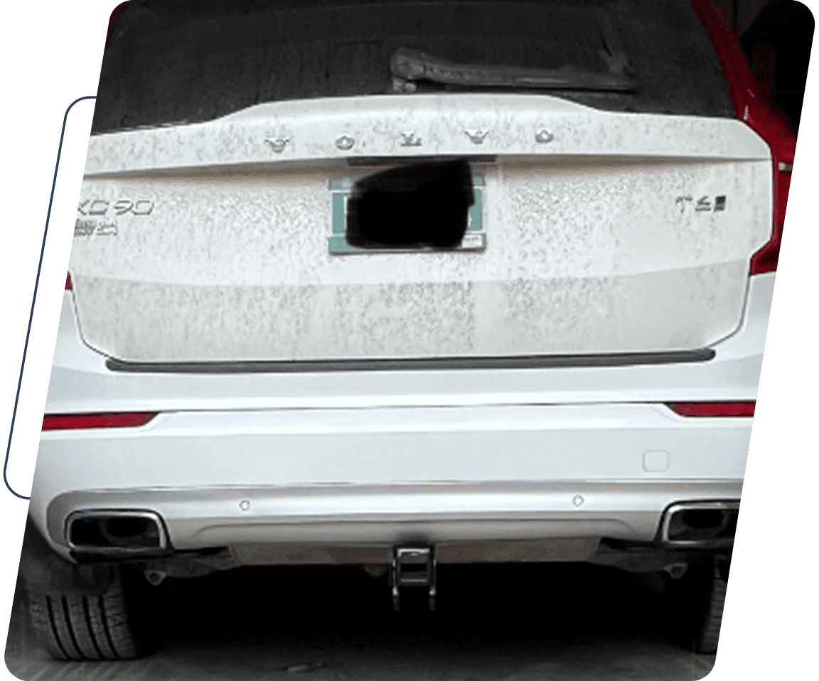 13 A white car with the trunk open and its back end broken.